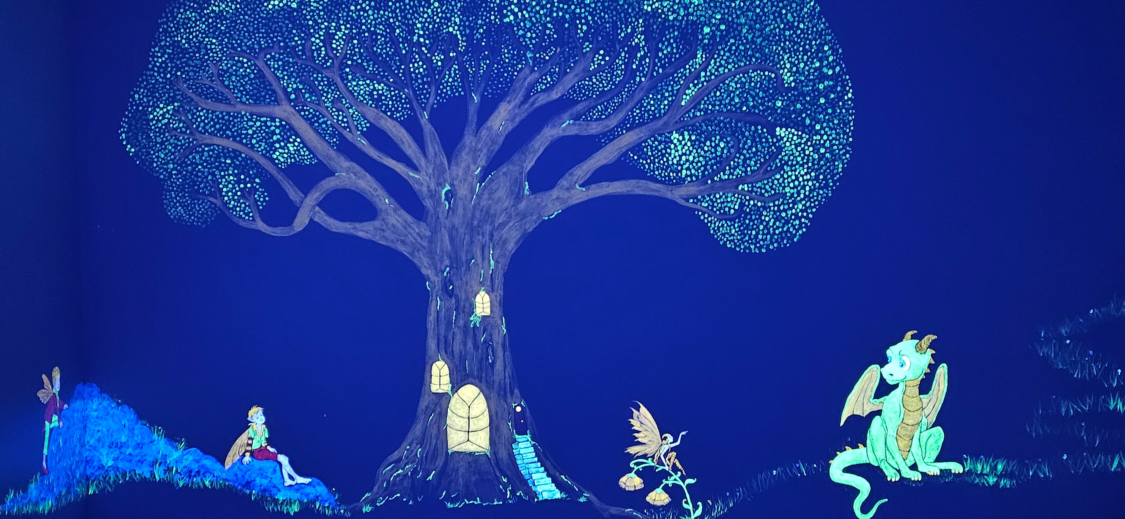 Enchanted tree with fairies, dragon and rabbit glowing under black light in the Fantasy Room