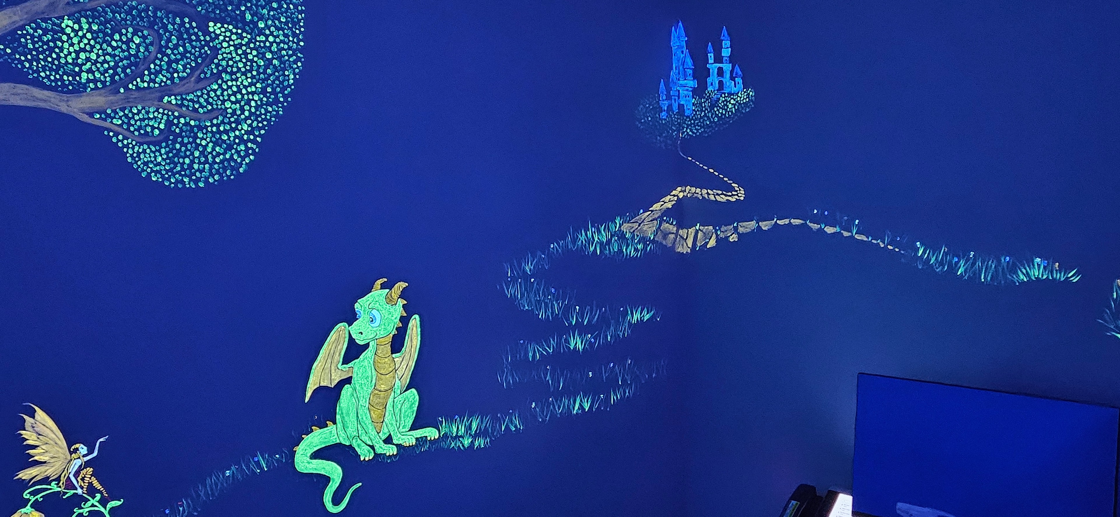 Dragon, fairy and floating castle glowing under black light in the Fantasy Room