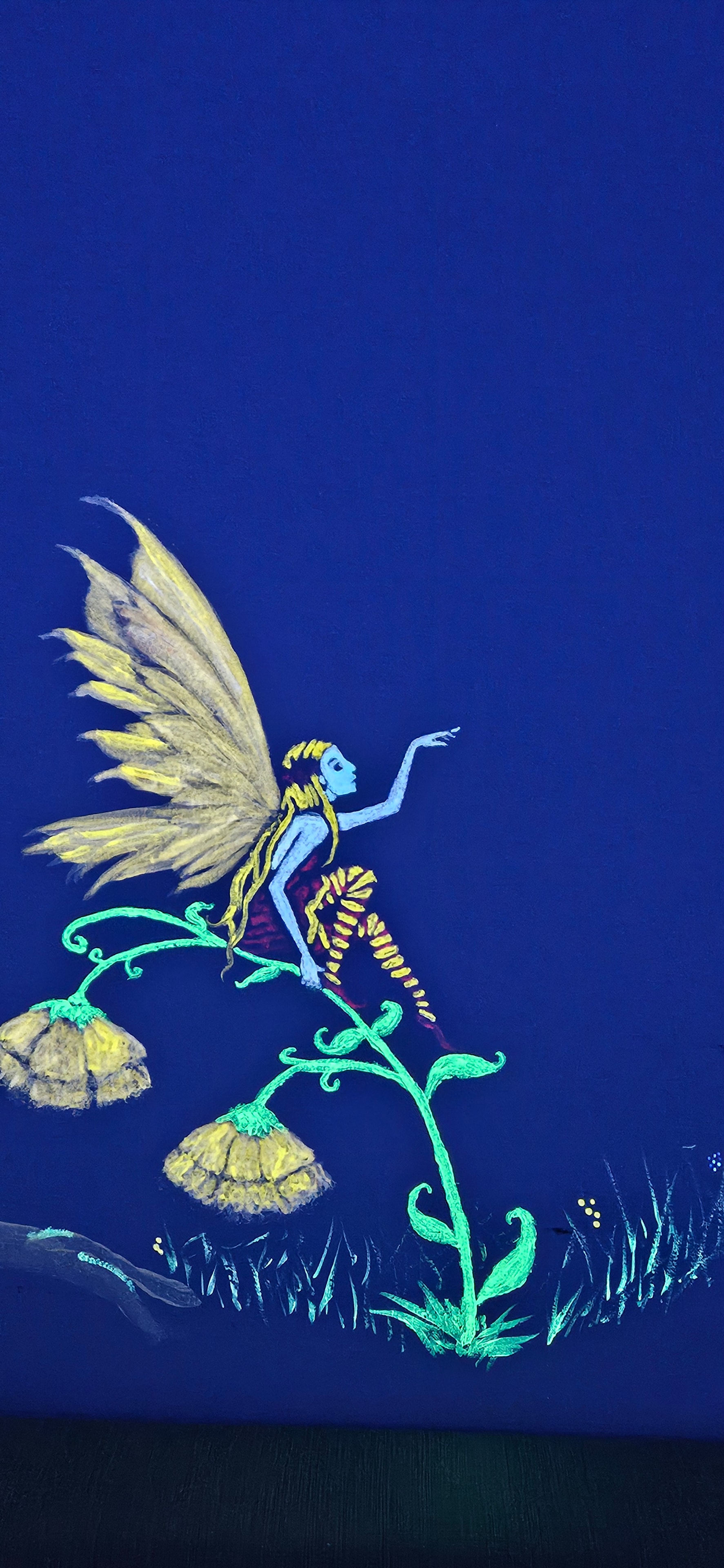 Glowing golden fairy floating beside a glowing vine and flowers under black light in the Fantasy Room