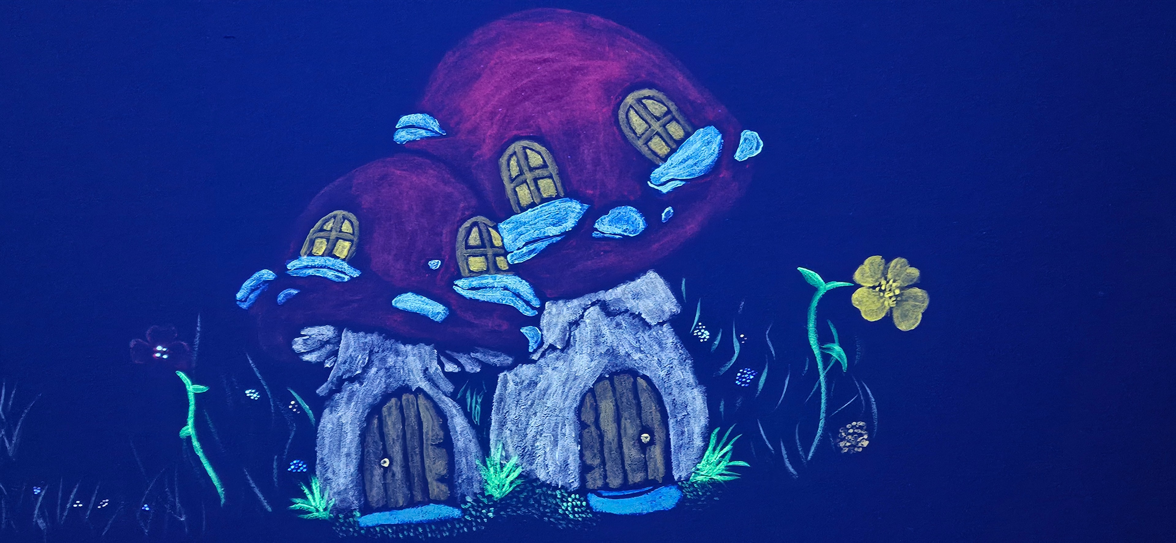 Glowing twin mushroom houses with arched wooden doors under black light in the Fantasy Room