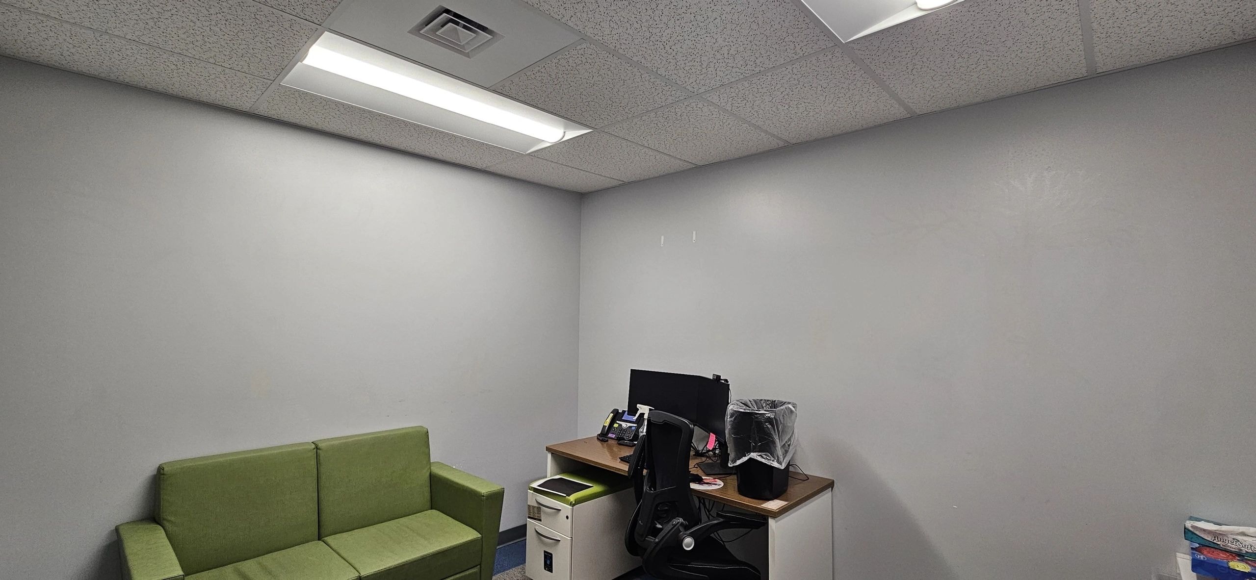 Fantasy room in normal light — office with green sofa and desk before black light art transformation