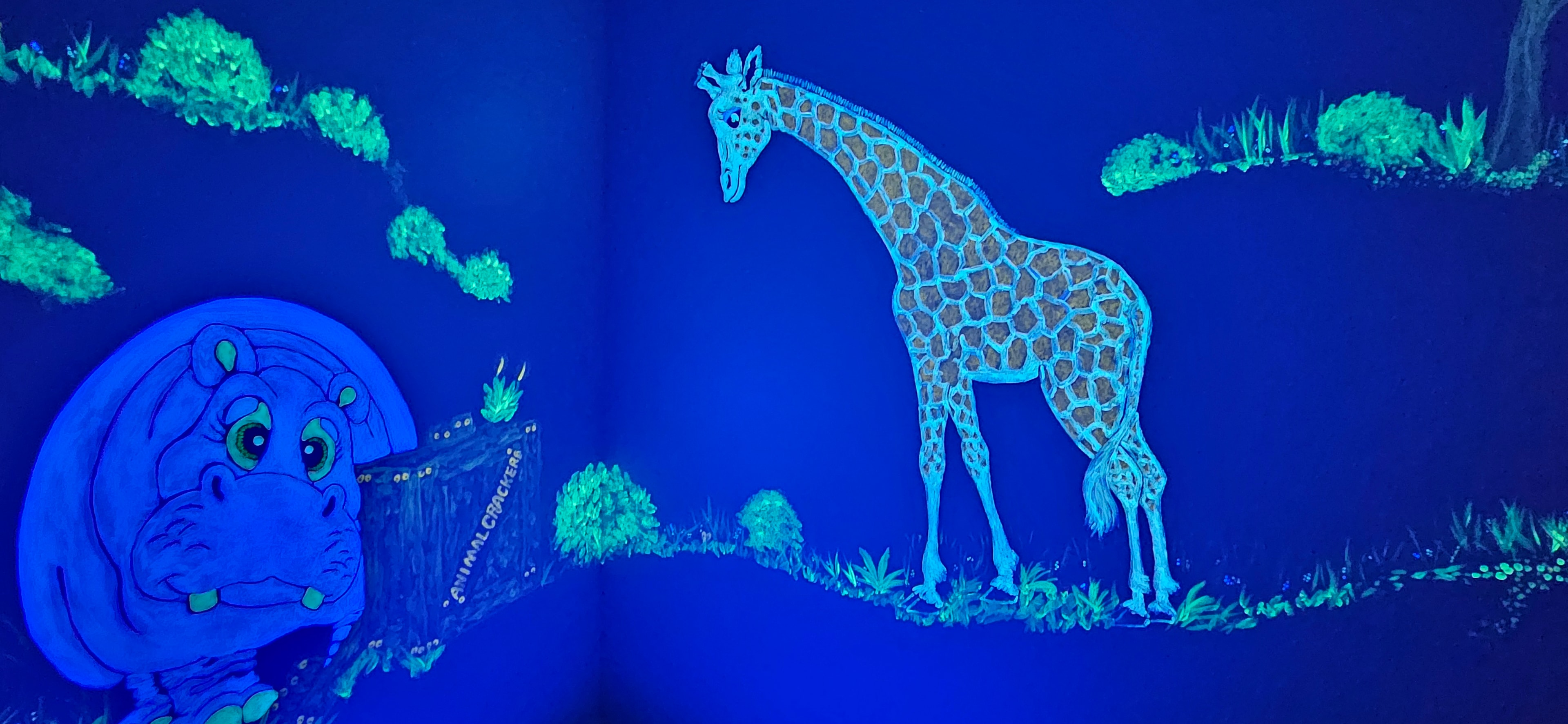 Jungle room glowing with hippo and giraffe under black light