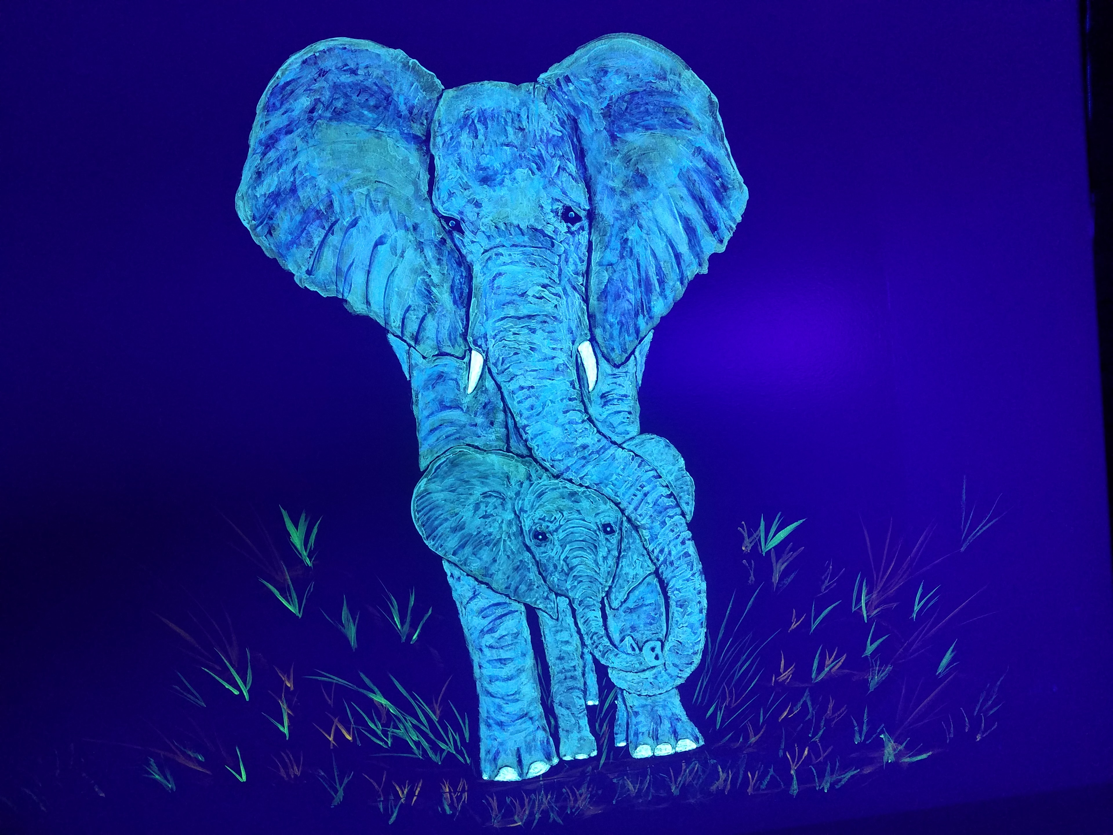 Glowing blue mother and baby elephant painted under black light in the Jungle Room