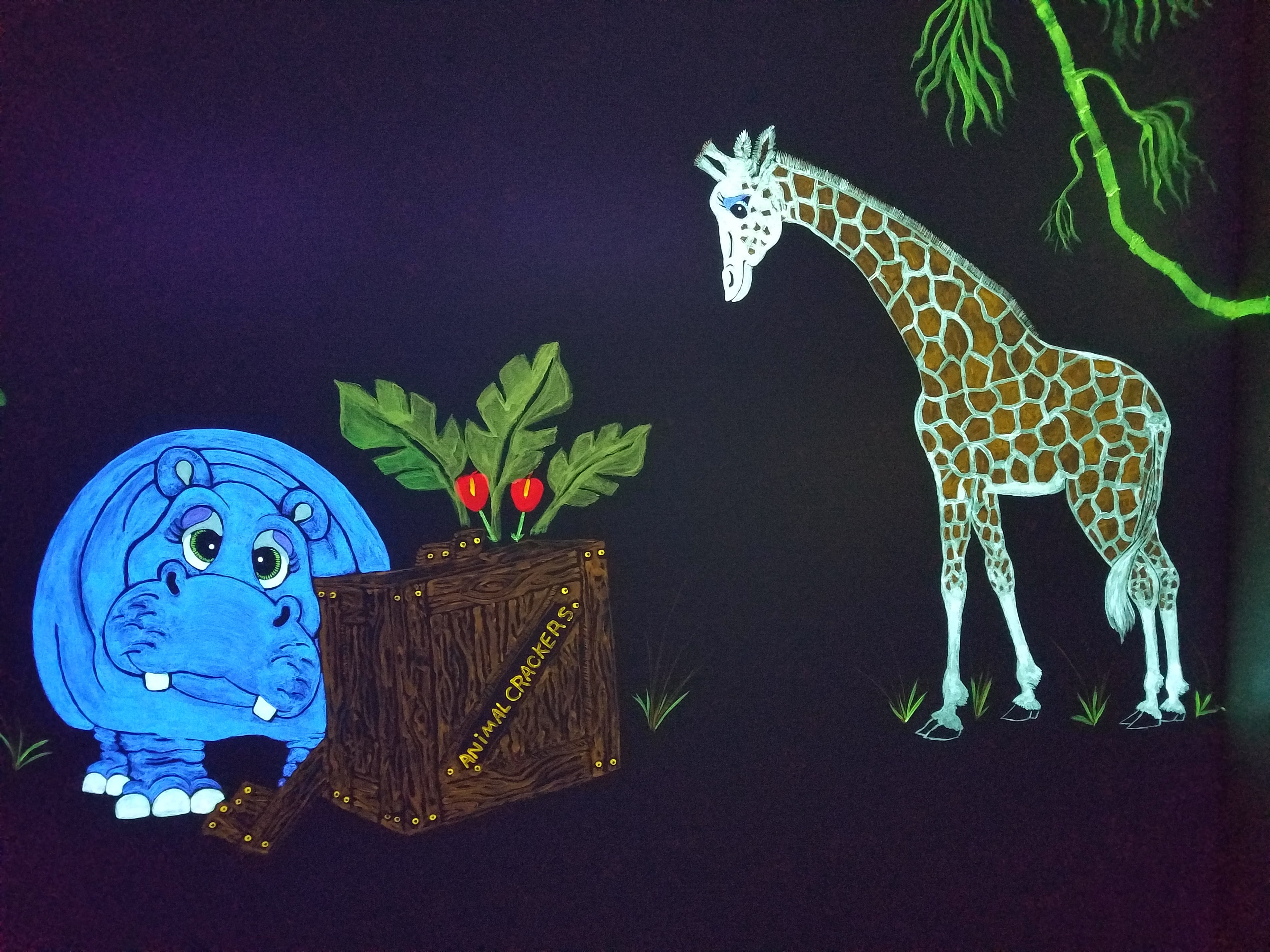Glowing blue hippo and giraffe with an Animal Crackers crate in the Jungle Room