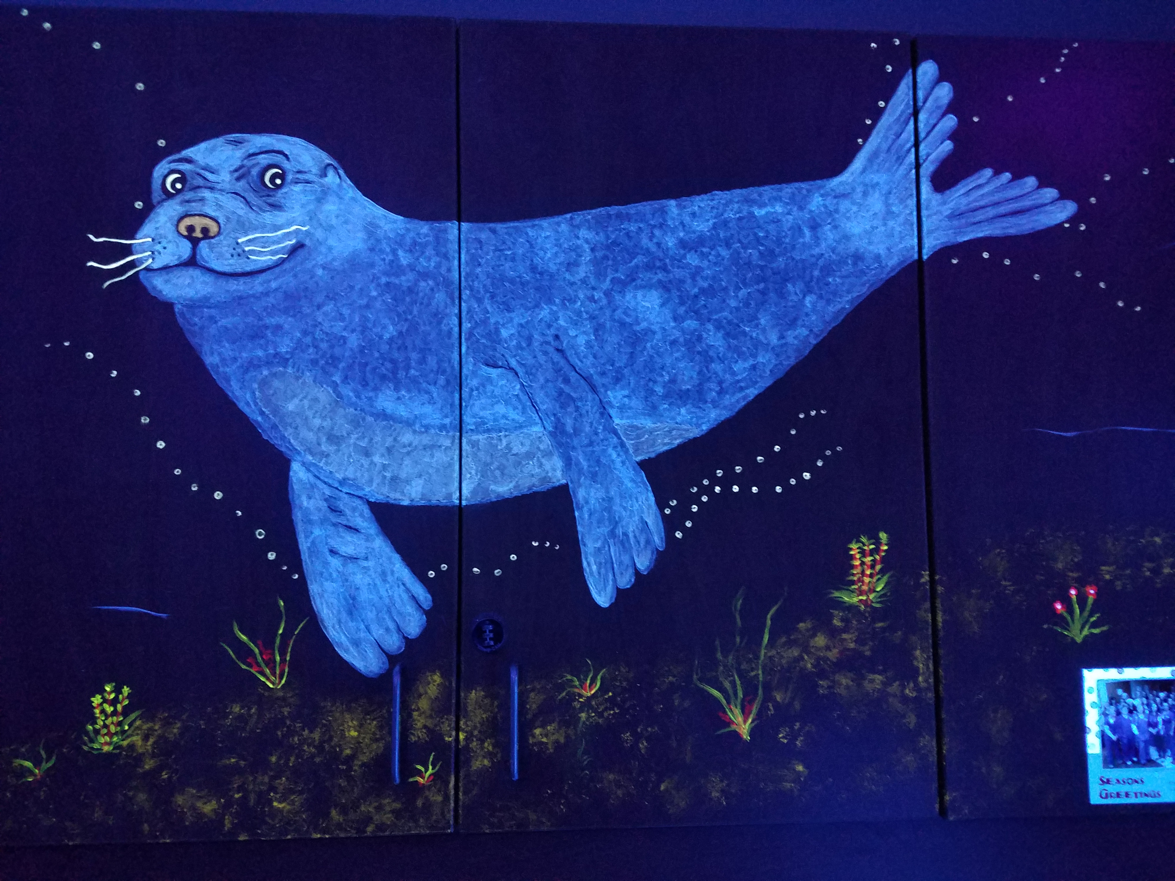 Glowing blue seal painted on the Ocean Room wall under black light